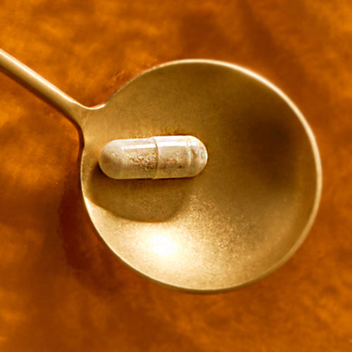Vitamin C als gepufferte Kapsel auf goldenem Löffel